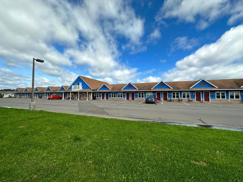 Travellers Inn and its green lawn beneath a dramatic blue sky